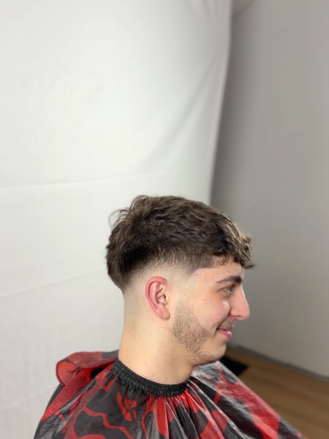 Coupe taper nette sur cheveux bouclés, vue de profil